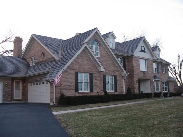 Cedar shake roof on a large brick home, installed by Adept Construction