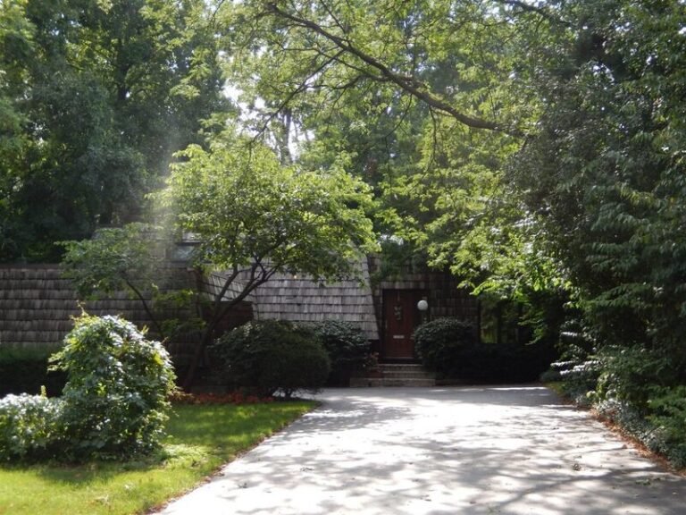 Cedar shake roof on a home among trees, installed by Adept Construction