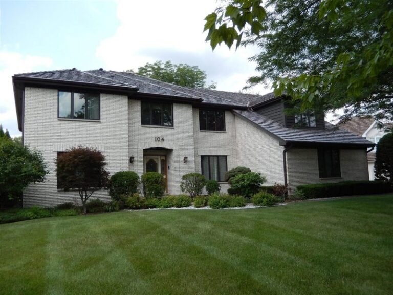 Cedar shake roof on a white two-story home, installed by Adept Construction