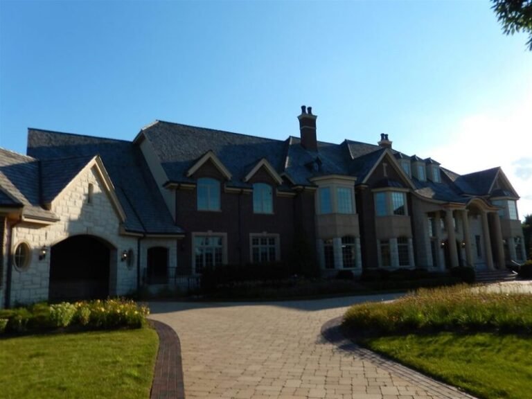 Cedar shake roof on a brick home with several gables, installed by Adept Construction