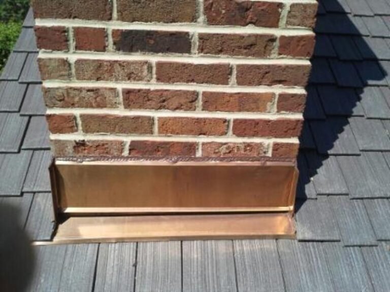 New metal flashing where a composite roof meets a brick chimney, by Adept Construction