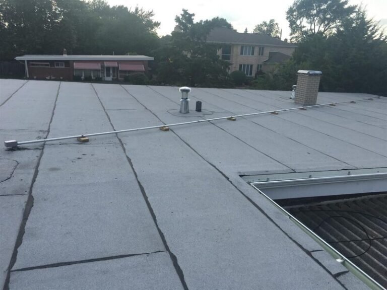 Modified bitumen cap sheet being torch-applied on a flat roof