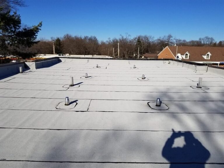 Low-slope membrane roof with roof drains on a commercial building, installed by Adept Construction
