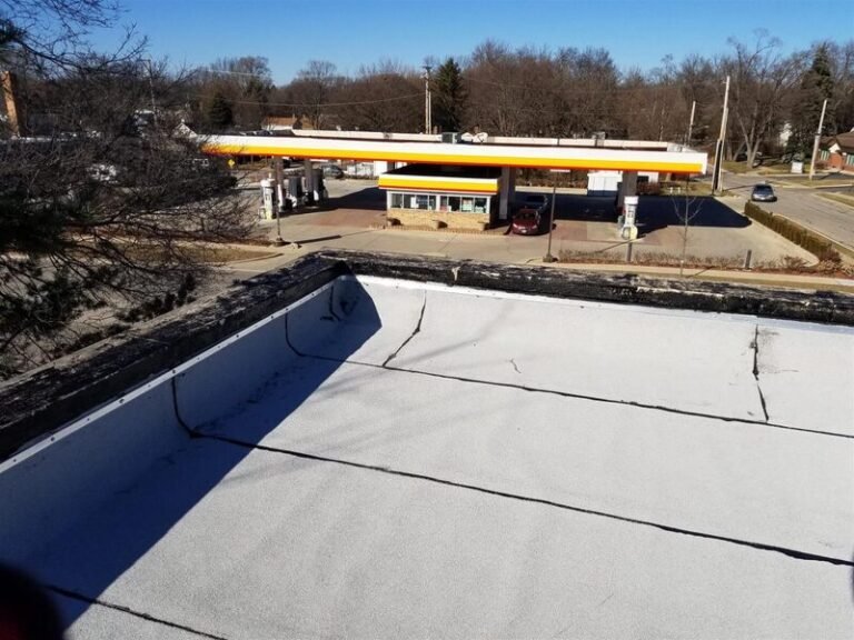 Flat commercial roof being installed with a rolled membrane and rooftop HVAC units