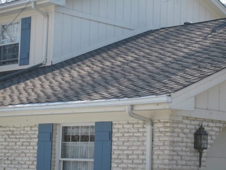 New seamless gutters along a shingle roof edge, installed by Adept Construction