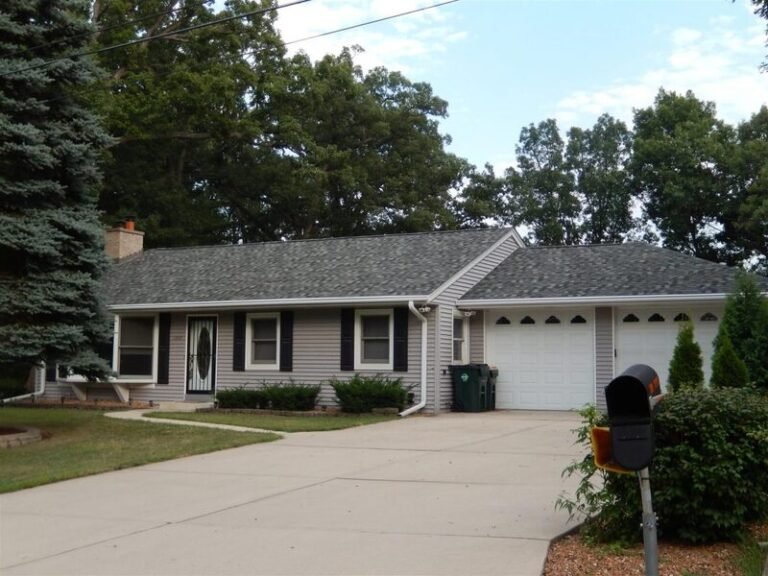 Roofing project by Adept Construction on a ranch home with white siding