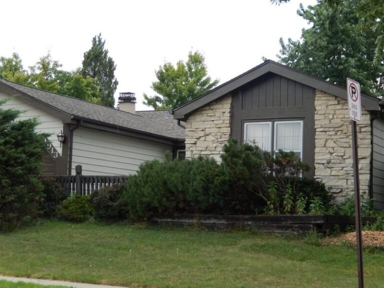 Roofing project by Adept Construction on a two-story home with a stone front
