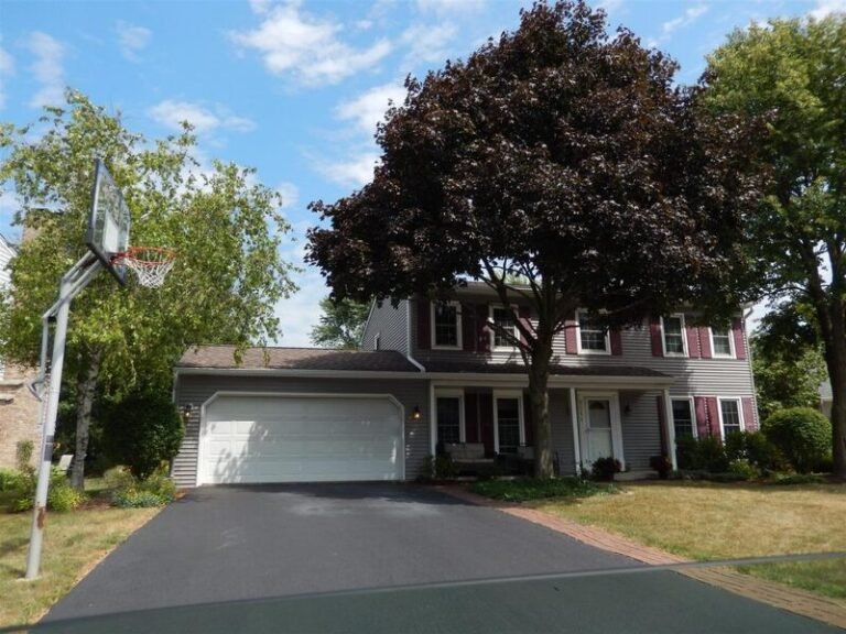 Roofing project by Adept Construction on a two-story home with a white garage door