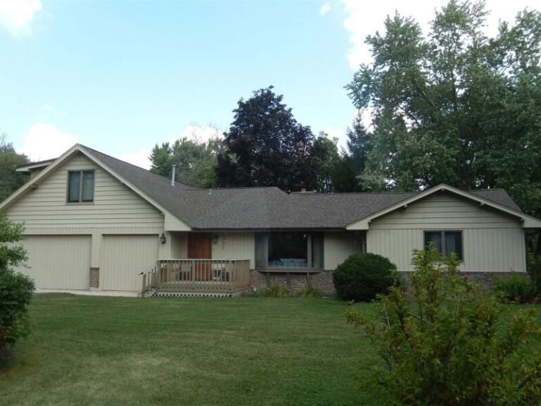 Roofing project by Adept Construction on a split-level home with a gray shingle roof