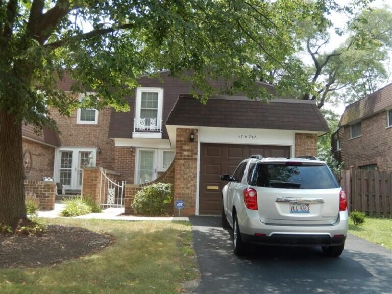 Roofing project by Adept Construction on a brick home with a front-facing garage