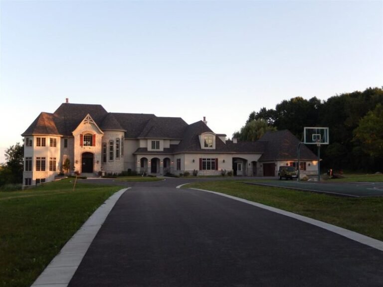 Roofing project by Adept Construction on a large brick home with several gables