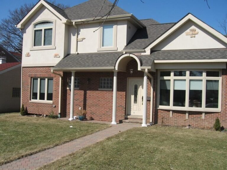 Roofing project by Adept Construction on a brick two-story home with an arched entry