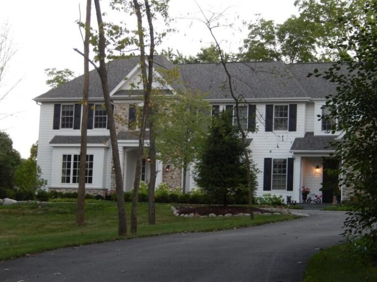 Roofing project by Adept Construction on a colonial home with dark shutters