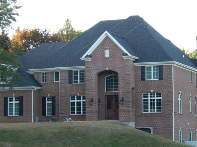 Roofing project by Adept Construction on a brick home with a steep gabled roof
