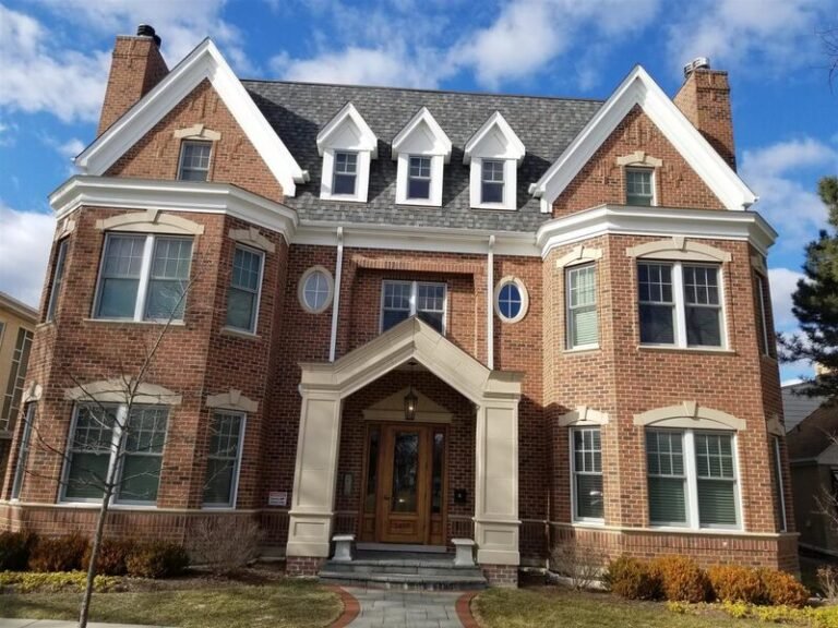 Roofing project by Adept Construction on a brick home with three dormers