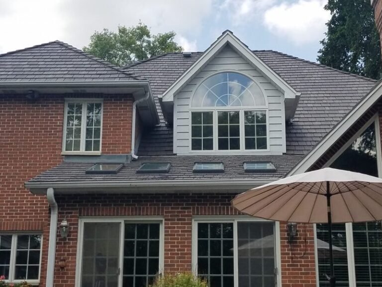 Roofing project by Adept Construction on a brick home with an arched upper window