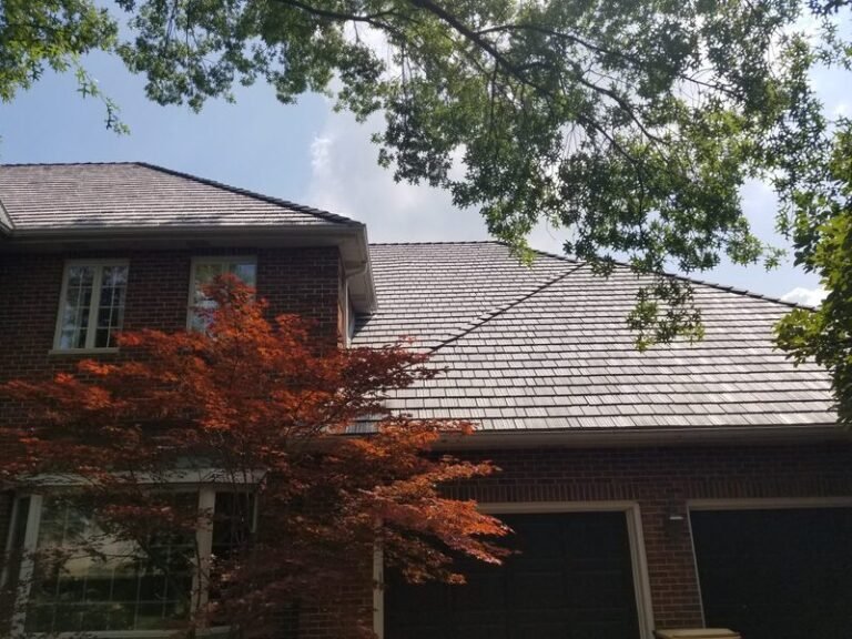 Roofing project by Adept Construction on a brick home with a red maple in front
