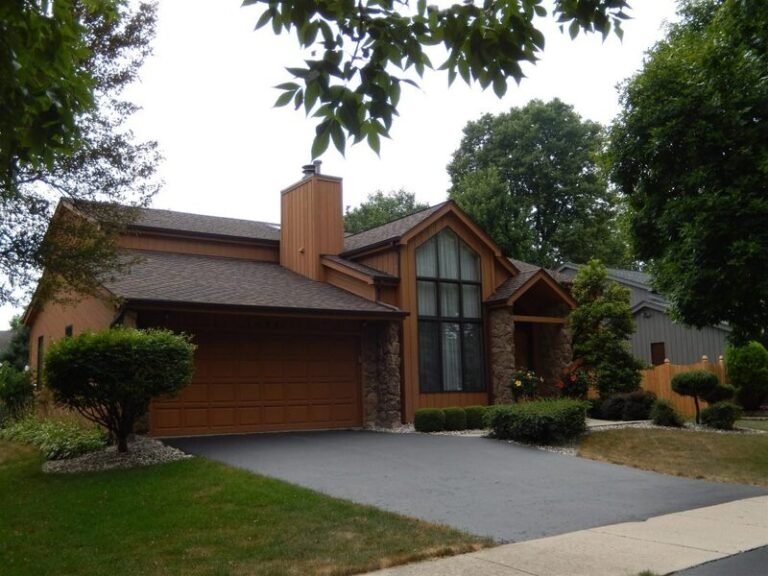 Roofing project by Adept Construction on a brick home with a tall chimney