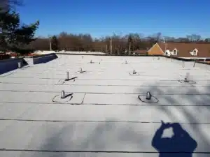 Wide view of an aging commercial flat roof with vents in Naperville, IL