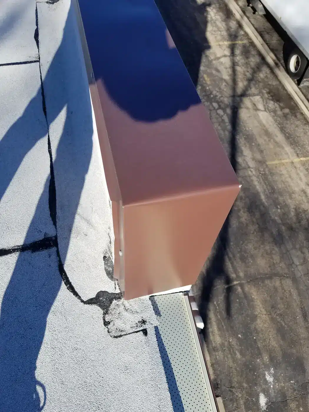 Cracked seam at a parapet corner on a Naperville, IL commercial flat roof